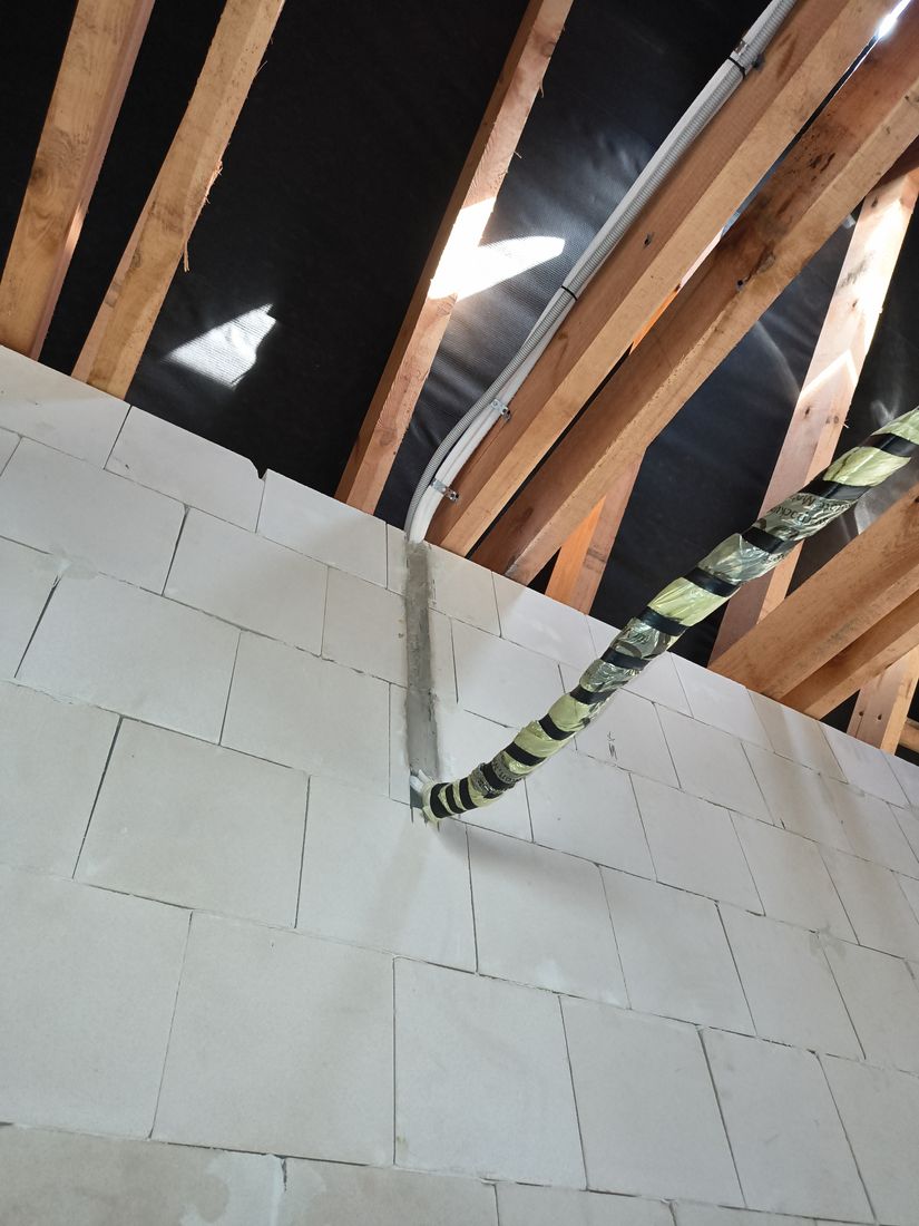Instalacja klimatyzacji wchodząca w ścianę na poddaszu przed tynkowaniem